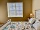 Cozy bedroom with a large window and a bed with a floral comforter providing a comfortable space at 14575 W Mountain View Blvd # 11313, Surprise, AZ 85374