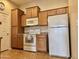 Functional kitchen with light wood cabinets, white appliances, and ample countertop space at 14575 W Mountain View Blvd # 11313, Surprise, AZ 85374