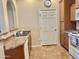Close up of the kitchen with a sink, dishwasher, stove, tile floors and a door leading to another room at 14575 W Mountain View Blvd # 11313, Surprise, AZ 85374