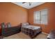 Cozy bedroom with orange walls, a plaid bedspread, dresser, carpet, and natural light at 1473 W Flamingo Dr, Chandler, AZ 85286