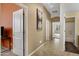 Hallway with open doorways, tile flooring, neutral paint, and an art piece on the wall at 1473 W Flamingo Dr, Chandler, AZ 85286