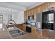 Kitchen featuring wood cabinets, granite countertops, stainless steel appliances, and a double sink at 1473 W Flamingo Dr, Chandler, AZ 85286