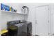 Functional laundry room with modern washer and dryer, shelving, and storage at 1473 W Flamingo Dr, Chandler, AZ 85286