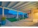 Covered backyard patio with a beautiful pergola and a well-maintained green space, perfect for outdoor entertaining at 15290 W Ventura St, Surprise, AZ 85379