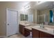 Bright bathroom includes double vanity sinks, a large mirror, and separate shower and toilet room at 15290 W Ventura St, Surprise, AZ 85379