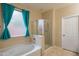 Bathroom featuring a soaking tub, frameless shower, and neutral color palette at 15290 W Ventura St, Surprise, AZ 85379