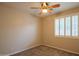 Comfortable bedroom featuring a ceiling fan and window with plantation shutters at 15290 W Ventura St, Surprise, AZ 85379