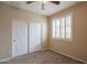 Bedroom with carpet, ceiling fan, window with shutters and a closet with sliding doors at 15290 W Ventura St, Surprise, AZ 85379