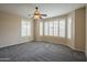 Cozy bedroom features a ceiling fan, neutral walls, and plenty of natural light from large windows at 15290 W Ventura St, Surprise, AZ 85379