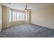 Bright, carpeted bedroom with ceiling fan features large windows and plenty of natural light at 15290 W Ventura St, Surprise, AZ 85379