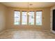 Dining area with backyard views through large windows and modern chandelier at 15290 W Ventura St, Surprise, AZ 85379