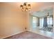 Dining room featuring an elegant chandelier, neutral walls and carpet, and an open view to the living room at 15290 W Ventura St, Surprise, AZ 85379