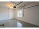 Clean garage with painted floor, fluorescent lighting and room for storage at 15290 W Ventura St, Surprise, AZ 85379