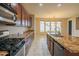 Gourmet kitchen featuring granite countertops, stainless steel appliances, and a view of the backyard at 15290 W Ventura St, Surprise, AZ 85379