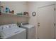 A well-lit laundry room with washer, dryer, shelving, and storage space at 15290 W Ventura St, Surprise, AZ 85379