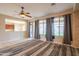 Bright living room with ceiling fan, large windows, and an open view to the kitchen at 15290 W Ventura St, Surprise, AZ 85379