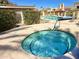 Inviting hot tub with clear blue water and community pool in the background at 16724 E Gunsight Dr # 118, Fountain Hills, AZ 85268