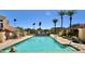 Community pool with sparkling clear water and palm trees in the background on a sunny day at 16724 E Gunsight Dr # 118, Fountain Hills, AZ 85268
