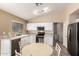 Bright kitchen features white cabinets, stainless steel appliances, and adjacent round table dining area at 16737 N 157Th Ave, Surprise, AZ 85374