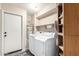 Functional laundry room with washer, dryer, shelving, and access to outside at 16737 N 157Th Ave, Surprise, AZ 85374
