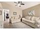 Cozy living room featuring neutral tones, plush seating, a ceiling fan, and an inviting atmosphere at 16737 N 157Th Ave, Surprise, AZ 85374