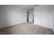 The carpeted bedroom includes an ensuite bathroom, a walk-in closet, and neutral paint at 17310 W Via Dona Rd, Surprise, AZ 85387