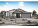 Charming single-story home with a neutral color scheme, desert landscaping, and a two-car garage, creating a welcoming curb appeal at 17310 W Via Dona Rd, Surprise, AZ 85387