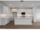 Bright, open kitchen boasts an island, white cabinets, modern appliances, and herringbone backsplash at 17310 W Via Dona Rd, Surprise, AZ 85387