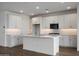 Bright kitchen features a central island, white cabinetry, stainless steel appliances, and decorative tile backsplash at 17310 W Via Dona Rd, Surprise, AZ 85387