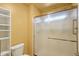 Bathroom featuring a glass-enclosed shower and a white toilet with a shelving unit at 19835 N Alta Loma Dr, Sun City West, AZ 85375