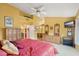 Bedroom with yellow walls, ceiling fan, comfortable bed, and furnishings, adjacent to the bathroom at 19835 N Alta Loma Dr, Sun City West, AZ 85375