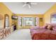 Bedroom with a ceiling fan, yellow walls, carpeting, and a bay window for natural light at 19835 N Alta Loma Dr, Sun City West, AZ 85375