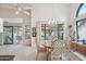 Sunlit dining area with round table, six chairs, and scenic views of the patio at 19835 N Alta Loma Dr, Sun City West, AZ 85375