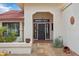 Inviting entryway with decorative security door, mature desert plants, and an arched covered porch at 19835 N Alta Loma Dr, Sun City West, AZ 85375