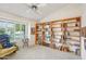 Comfortable living room featuring a floor to ceiling bookshelf and ample natural light at 19835 N Alta Loma Dr, Sun City West, AZ 85375