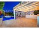 Lovely backyard featuring a swimming pool, covered patio, outdoor kitchen, and string lights at 20088 E Maya Rd, Queen Creek, AZ 85142