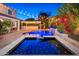 Backyard oasis with a pool, spa, and a charming outdoor kitchen with string lights and lush landscaping at 20088 E Maya Rd, Queen Creek, AZ 85142
