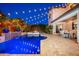 Inviting backyard featuring a pool, spa, waterfall, and string lights against a beautiful evening sky at 20088 E Maya Rd, Queen Creek, AZ 85142