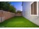 Backyard with artificial turf, bordered by a tall block wall for privacy at 20088 E Maya Rd, Queen Creek, AZ 85142