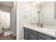 A well-lit bathroom featuring a gray vanity with light countertops, a mirror, and wood-look flooring at 20088 E Maya Rd, Queen Creek, AZ 85142