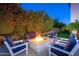 Cozy fire pit with ample seating surrounded by lush greenery, offering a private retreat at 20088 E Maya Rd, Queen Creek, AZ 85142