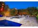 Cozy hot tub with an adjacent fire pit area, surrounded by lush greenery and ambient lighting at 20088 E Maya Rd, Queen Creek, AZ 85142
