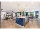 Open floor plan with kitchen island and pendant lighting, seamlessly flowing into the living and dining areas at 20088 E Maya Rd, Queen Creek, AZ 85142