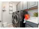 An organized laundry room featuring modern washer and dryer units with upper and lower gray cabinets at 20088 E Maya Rd, Queen Creek, AZ 85142