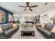 Open concept living room flows from the kitchen and is furnished with two sofas, chairs and a ceiling fan at 20088 E Maya Rd, Queen Creek, AZ 85142