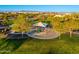 Community playground with shade structure, surrounded by grassy areas and trees at 20088 E Maya Rd, Queen Creek, AZ 85142