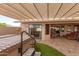 Hot tub under a slatted pergola, complemented by lush artificial grass and seamless access to the home's interior at 20215 N Broken Arrow Dr, Sun City West, AZ 85375