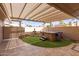 Relaxing backyard oasis featuring a covered patio, a hot tub, a small fountain, and manicured artificial grass at 20215 N Broken Arrow Dr, Sun City West, AZ 85375