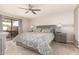 Carpeted main bedroom with a ceiling fan and access to a private outdoor space at 20215 N Broken Arrow Dr, Sun City West, AZ 85375