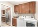 Laundry room with wood cabinets, sink, and a washer and dryer at 20215 N Broken Arrow Dr, Sun City West, AZ 85375